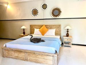 - une chambre dotée d'un grand lit avec un oiseau assis dans l'établissement Ubud River Campuhan Villa, à Ubud