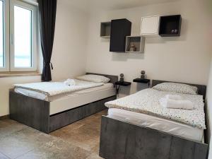 two twin beds in a room with a window at Bellavista Resort in Koper
