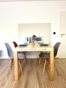 una mesa de comedor con sillas alrededor en Komfort Ferienwohnung nähe Bosenberg, en Sankt Wendel