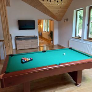 a pool table in a living room with a tv at Vila Cedra in Predeal