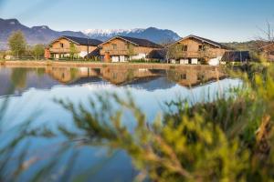 vista su un lago con case e montagne di Green Resort Bran a Bran