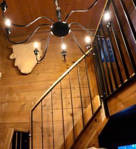 uma escadaria com um lustre e uma almofada branca em Sonniges Chalet Arosa für 6 Pers alleinstehend mit traumhaftem Bergpanorama em Langwies