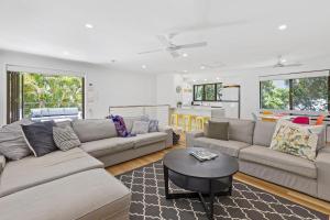 a living room with two couches and a table at Graebill 2 Bedroom 2 Bathroom Light and Spacious Duplex Walk to Beach Great Outdoor Entertaining Area in Sunshine Beach