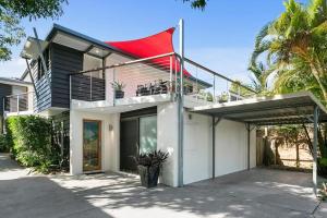 a house with a red banner on the side of it at Graebill 2 Bedroom 2 Bathroom Light and Spacious Duplex Walk to Beach Great Outdoor Entertaining Area in Sunshine Beach