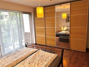een slaapkamer met een bed en een kamer met uitzicht bij MoPa - Stylisch wohnen zwischen Alb und Legoland in Leipheim