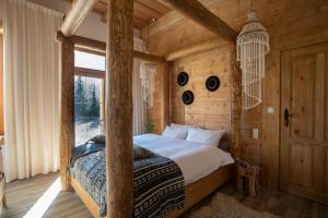 a bedroom with a poster bed in a log cabin at Niedźwiedzia Residence in Poronin