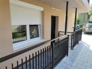 a house with a fence and a window at JOKER Apartman in Požarevac
