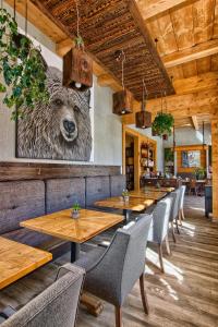 a restaurant with wooden tables and a bear head on the wall at Niedźwiedzia Residence in Poronin