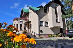 a large house with flowers in front of it at Vila Krantas in Palanga