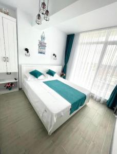 a bedroom with a large bed with blue and white at SUNSET MEMORIES ApartHotel Pool & Spa Mamaia Nord in Mamaia Nord