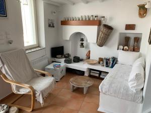 a living room with a desk and a couch and a chair at Anna s House in Chora in Astypalaia