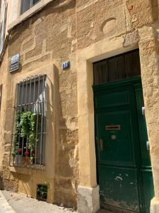 a building with a green door and a window at Le Madeleine (duplex) in Aix-en-Provence