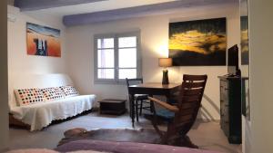 a bedroom with a desk and a bed and a window at La Forgeolie in Causses-et-Veyran