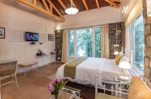 a bedroom with a bed and a living room at Sakley's Cottages in Nainital