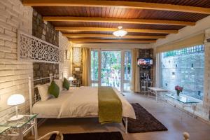 a bedroom with a bed and a brick wall at Sakley's Cottages in Nainital