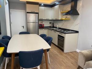 a kitchen with a table and some blue chairs at premium park apart otel in Kemer