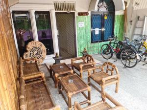 een groep houten banken op een veranda bij Traveller Home in Tangerang