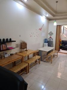 een kamer met houten banken en een tafeltennistafel bij Traveller Home in Tangerang