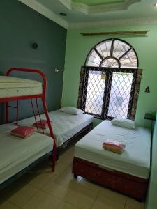 a room with two bunk beds and a window at Traveller Home in Tangerang