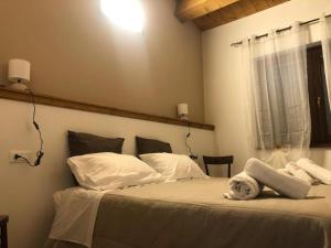a bedroom with a bed with white sheets and pillows at Agriturismo NONNU LUI` in Amandola