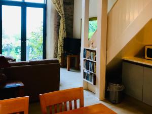 a living room with a couch and a book shelf at Peregrine hall in Lostwithiel