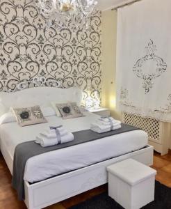 a bedroom with a white bed with towels on it at Il giardino in Canicattì