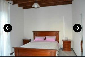 ein Bett in einem Schlafzimmer mit zwei Pfeilen an der Wand in der Unterkunft beb Palazzo del Conte in Castelluccio Valmaggiore