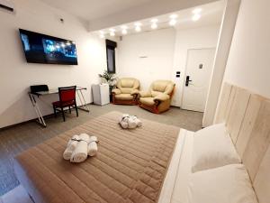 a bedroom with a bed with two pairs of shoes on it at Camere Fiera Verona - CasaNostra in Verona +30 photos