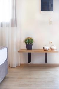 una pianta seduta su un tavolo di legno in una stanza di 9 Luxury Rooms a Sárti