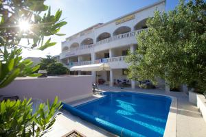 
a large white swimming pool in front of a house at Hotel Villa Daniela in Bol
