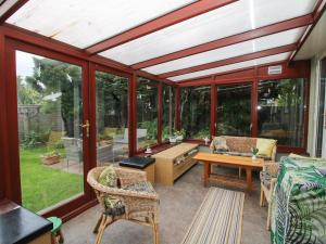 a conservatory with glass doors and a table and chairs at Roseland in Ludlow