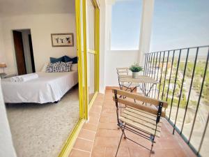 een slaapkamer met een bed en een balkon met een tafel bij ESTUDIO BLEGAMAR VISTAS - Playa, WiFi y Aparcamiento in El Puerto de Santa María