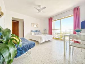 sala de estar con cama y ventana grande en ESTUDIO BLEGAMAR VISTAS - Playa, WiFi y Aparcamiento, en El Puerto de Santa María