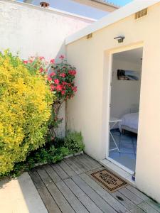 a door to a room with flowers and a bedroom at Chambre cosy indépendante dans jardin verdoyant. in Le Bouscat