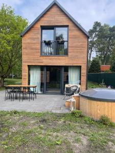 a house with a patio and a hot tub at Domek z Jacuzzi in Mrzeżyno