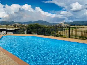 a large blue swimming pool with mountains in the background at Cedar Apartments - Merrijig in Merrijig