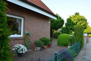 a brick house with flowers and plants on a patio at Ferienwohnung Ostfriesenglück in Leer