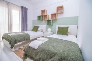 キンタ・ド・ラーゴにあるApartment close to golf, beaches, Quinta Lago, Vale Lobo, Quarteira and Vilamouraの緑と白の部屋のベッド2台