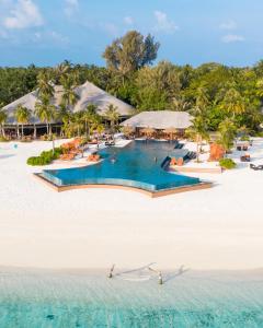 a large white swimming pool with a blue sky at Kihaa Maldives in Baa Atoll