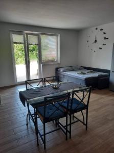 een woonkamer met een tafel en een bed bij Apartma Maks & Anita in Bovec