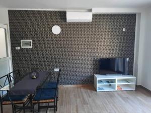 een eetkamer met een tafel en een tv aan de muur bij Apartma Maks & Anita in Bovec