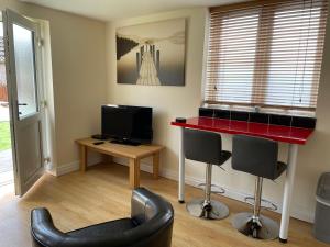 a living room with a red counter and two chairs at Garden flat near the University of York in York