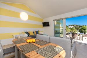- une salle à manger avec une table et un canapé dans l'établissement Apartment PORTAPISANA just 50m from the beach, à Krk