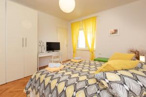クルクにあるApartment PORTAPISANA just 50m from the beachの大きなベッドとテレビのある寝室