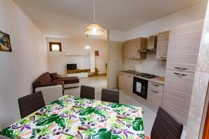 a kitchen and a dining room with a table and chairs at SanvitoTour - Appartamenti Tajine in San Vito lo Capo