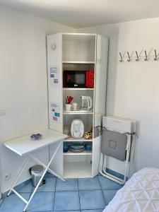 Cette chambre comprend un bureau et un réfrigérateur blanc. dans l'établissement Chambre cosy indépendante dans jardin verdoyant., à Le Bouscat