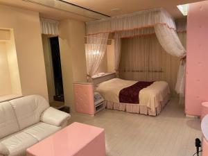 sala de estar con cama y sofá en ホテル隠宿 凛 Rin, en Ōgaki