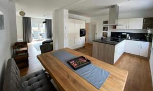 a kitchen and a living room with a wooden table at Ferienhaus Bimmelbahn 2 in Olbersdorf