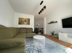 ein Wohnzimmer mit einem grünen Sofa und einem TV in der Unterkunft Ferienhaus Bimmelbahn in Olbersdorf