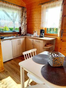 a kitchen with a table and chairs in a cabin at Domki Letniskowe Paula in Darłowo